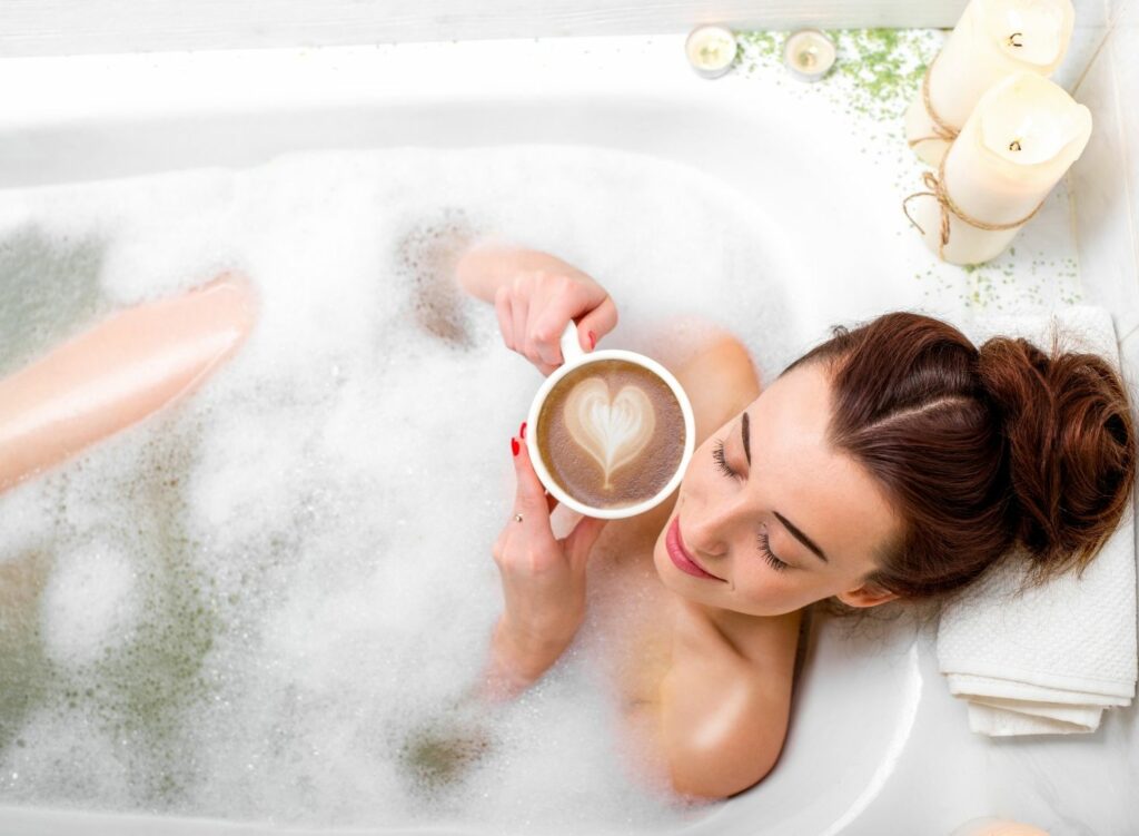 Frau genießt eine Tasse Kaffee in der Badewanne